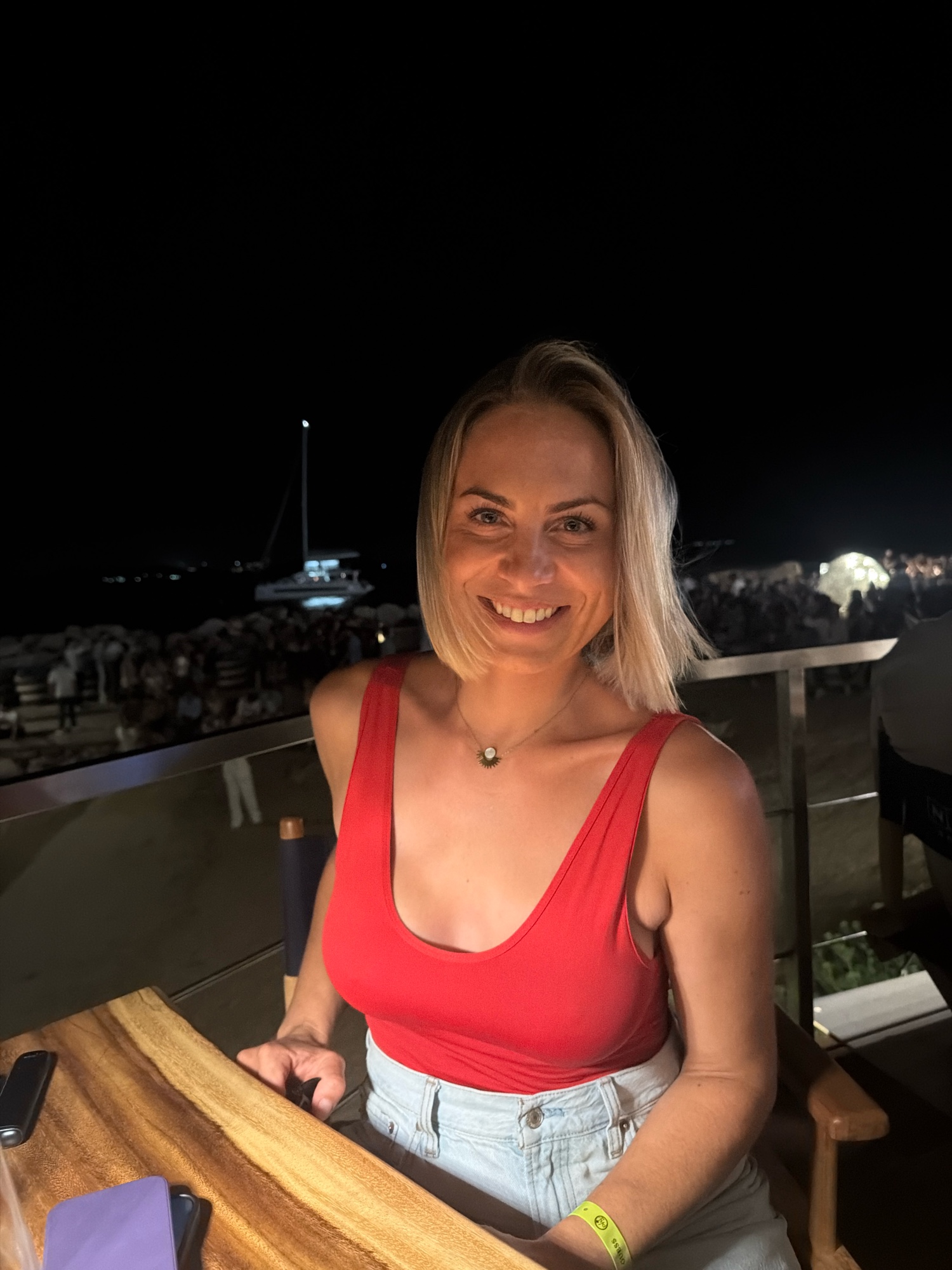 Lou, souriante, un soir d'été au bord de l'eau en Sardaigne
